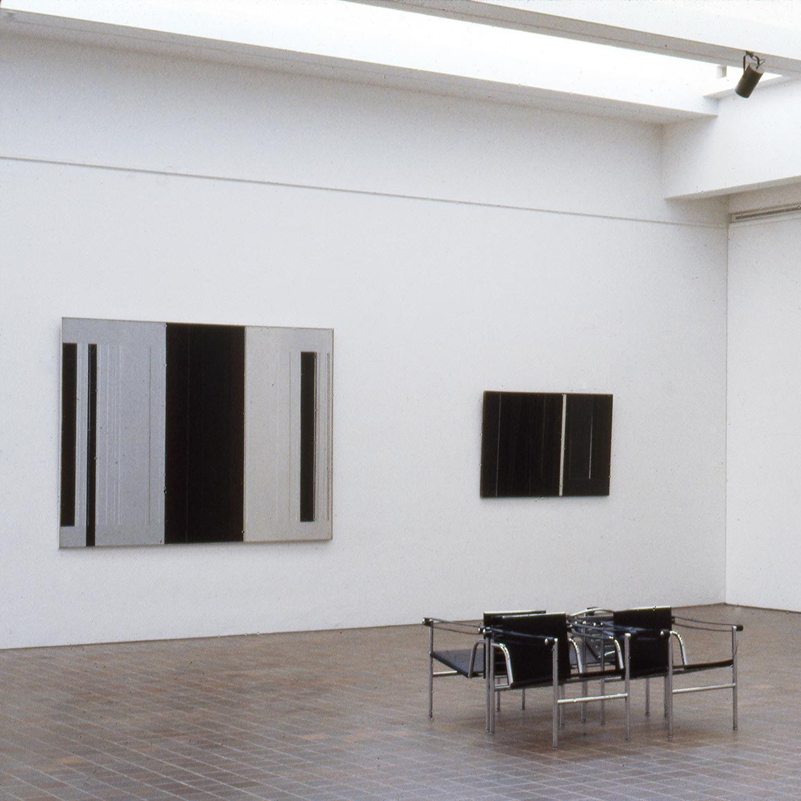 Salle d'exposition du musée présentant deux tableaux au mur.