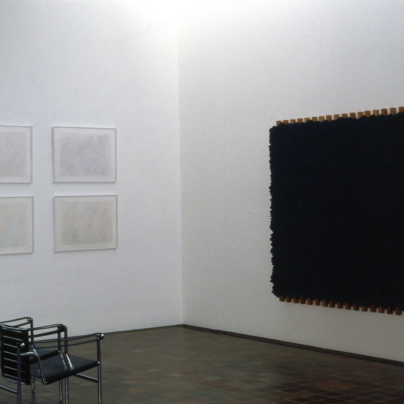 Salle d'exposition présentant des œuvres aux murs.