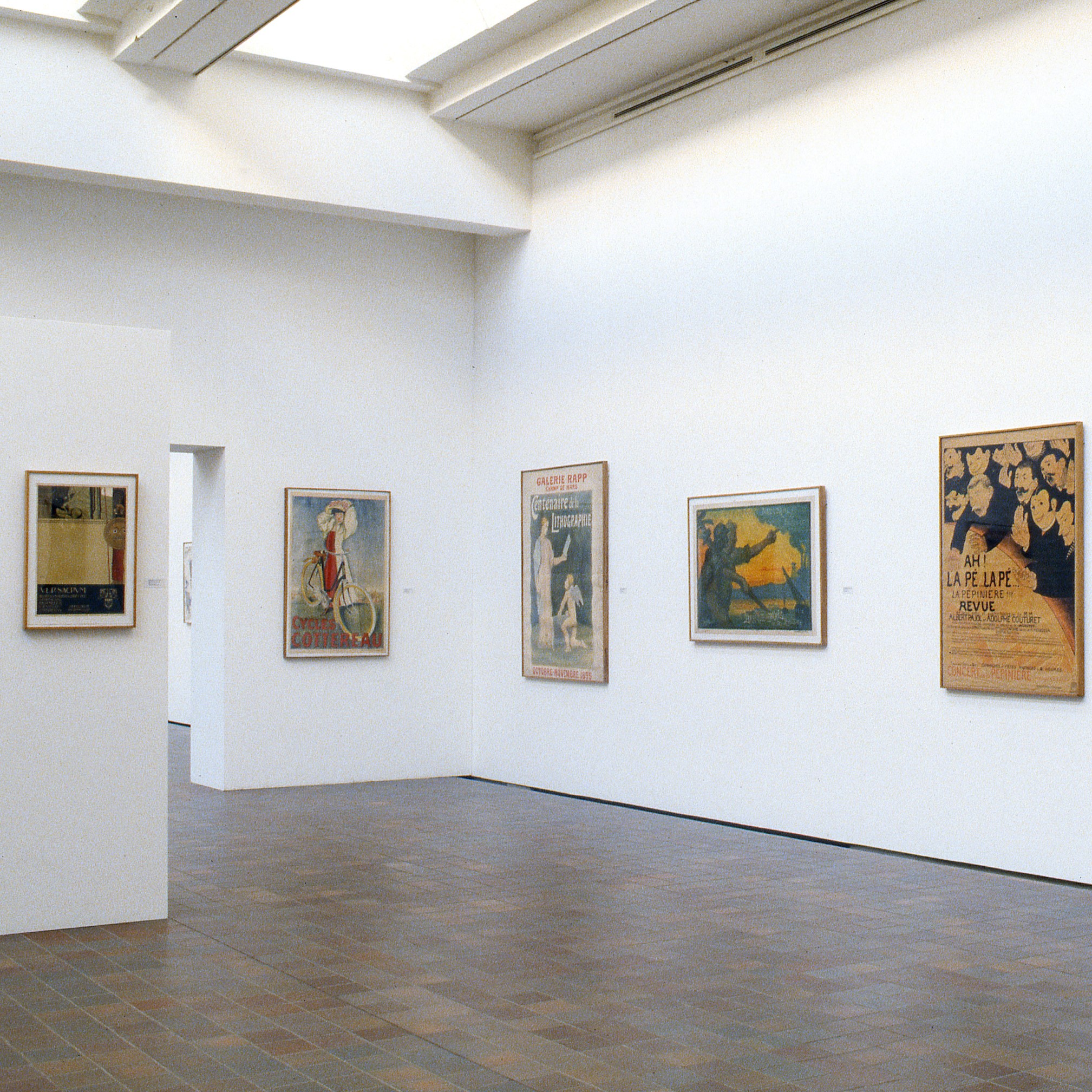 Salle d'exposition présentant des toiles.