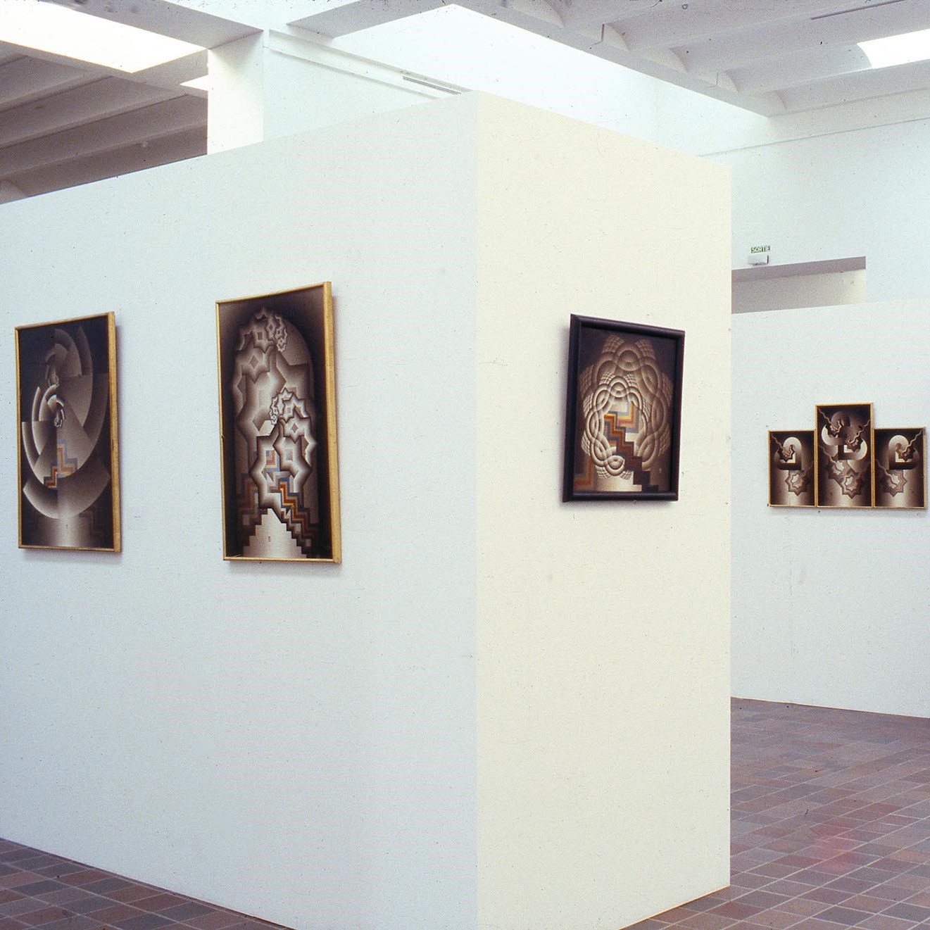 Salle d'exposition présentant des tableaux sur une cimaise et sur le mur.