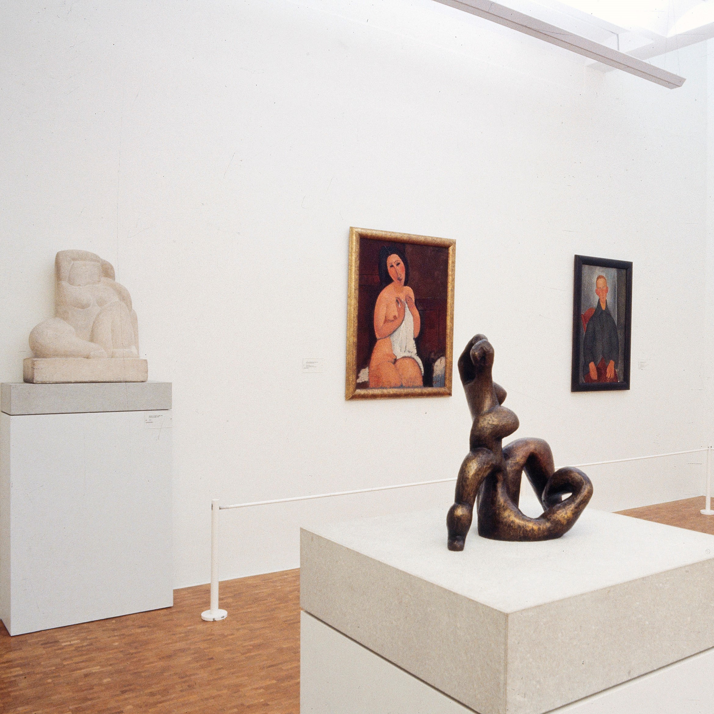 Salle d'exposition présentant des toiles et des sculptures.