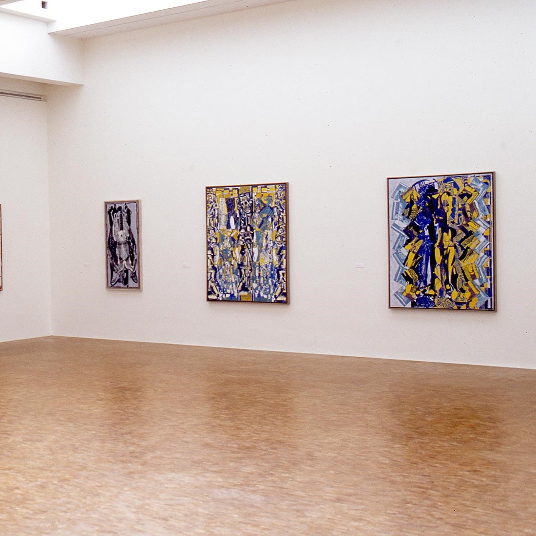 Salle d'exposition avec trois tableaux au mur.