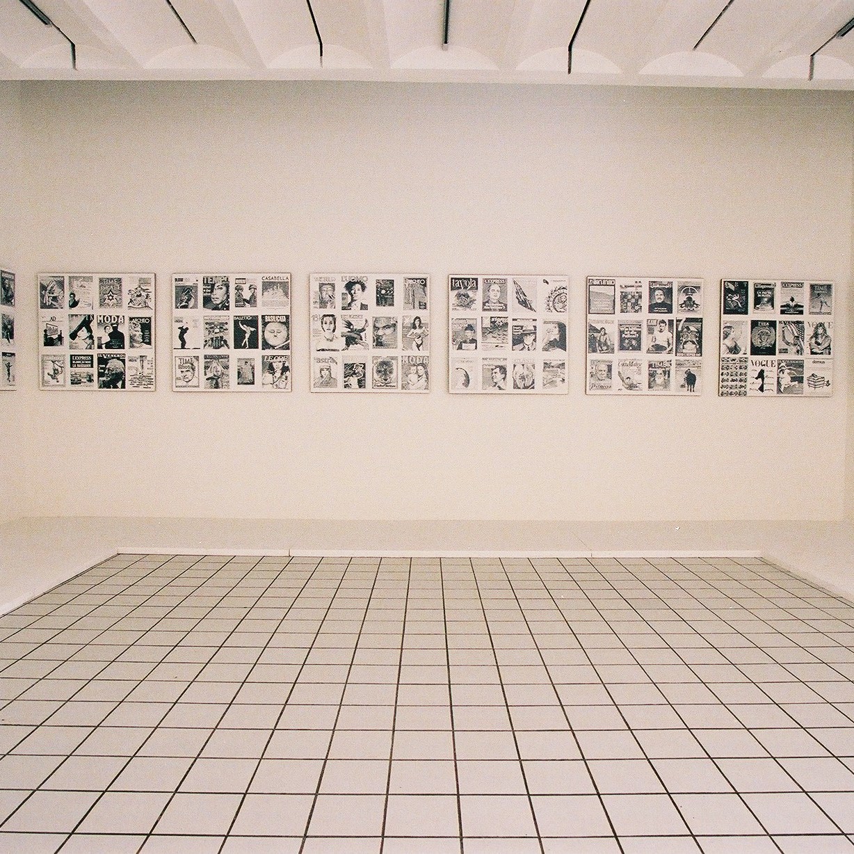 Salle d'exposition du musée avec tableaux en noirs et blancs aux murs.
