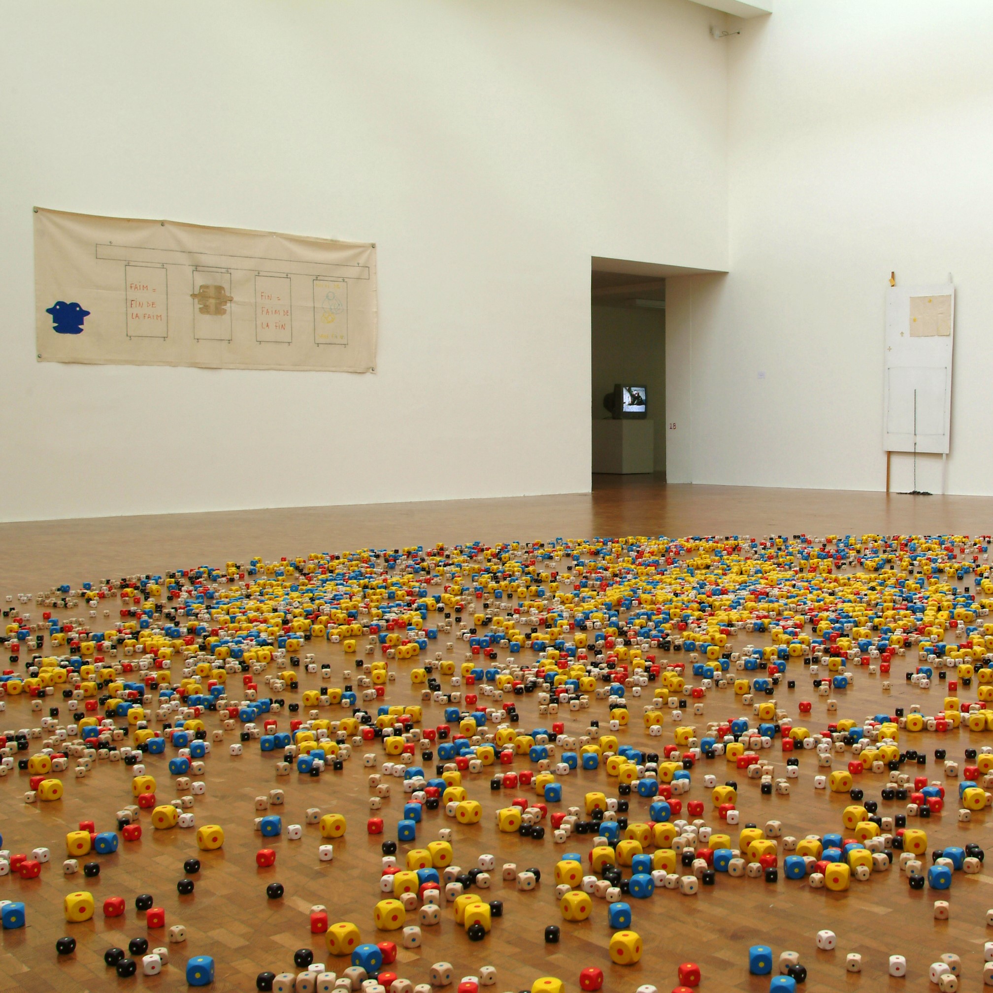 Salle d'exposition remplit de dés au sol.