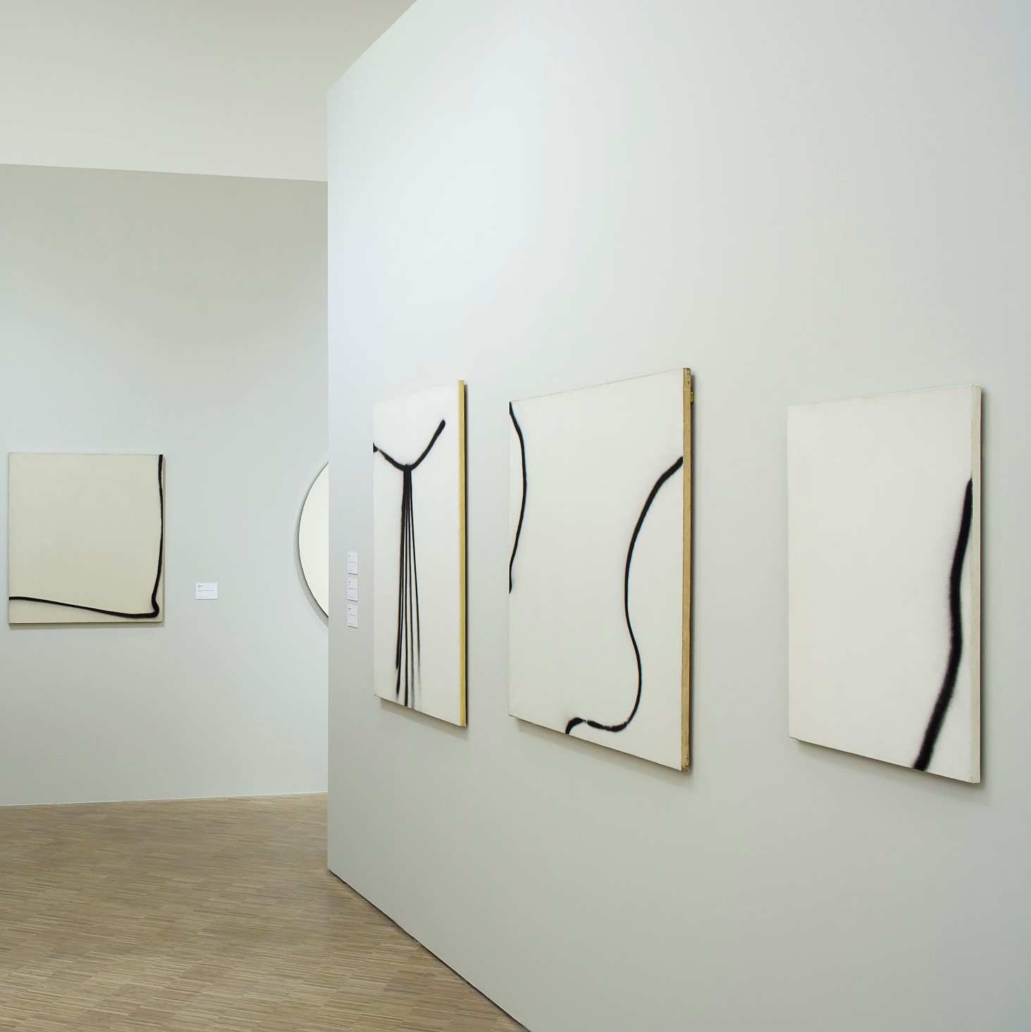 Toiles noires et blanches dans une salle d'exposition.