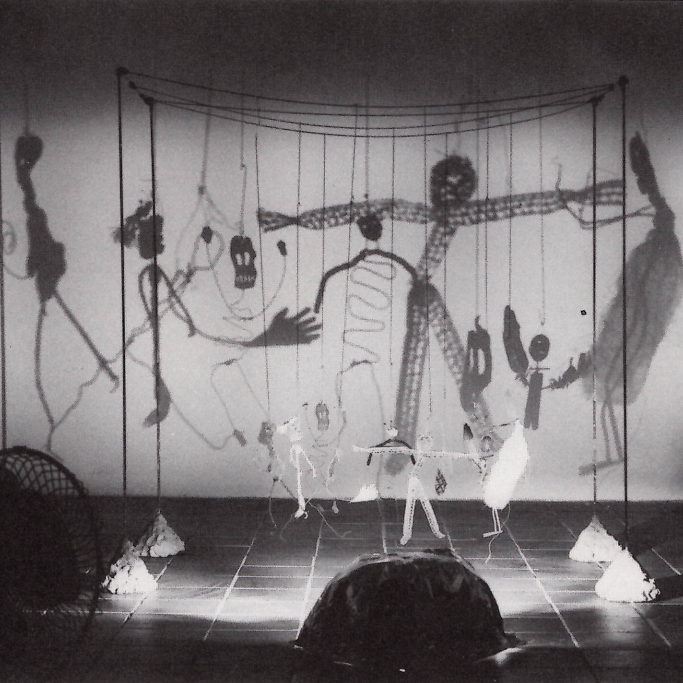 Projection de lumière sur des sculptures faisant apparaitre au mur de grandes ombres. 