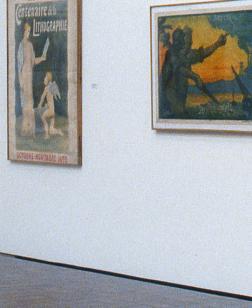 Salle d'exposition présentant des toiles.