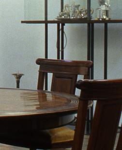 Salle d'exposition présentant du mobilier d'art décoratif, table et chaises.