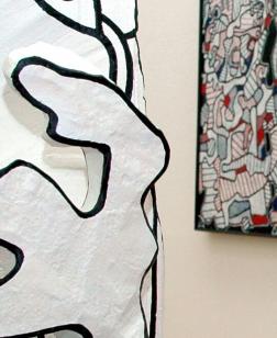 Salle d'exposition, sculpture au centre et toile au mur.