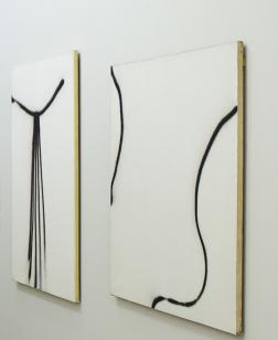 Toiles noires et blanches dans une salle d'exposition.