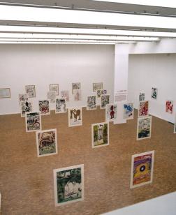 Salle d'exposition, œuvres graphiques suspendues.