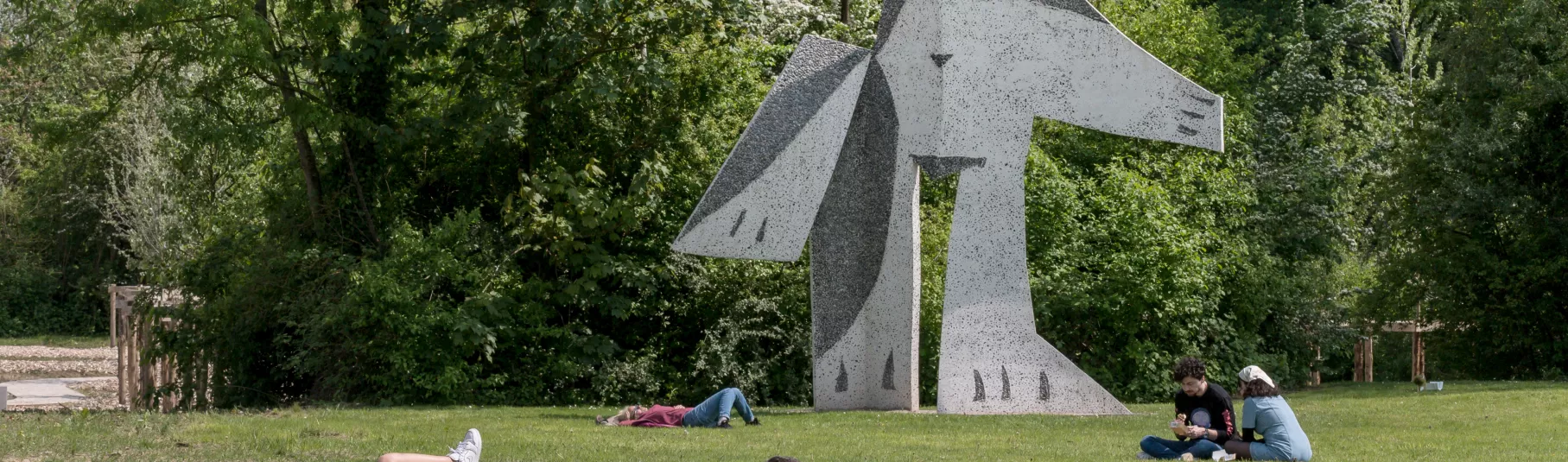 Sculpture dans le parc du musée avec visiteurs.