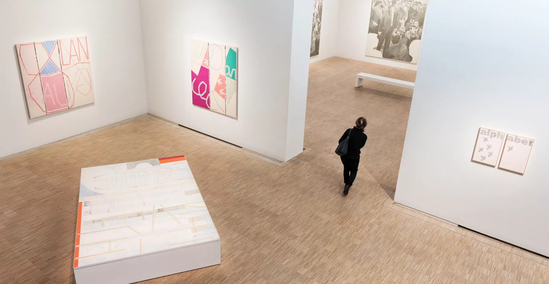 Salle d'exposition vue de haut avec un visiteur.