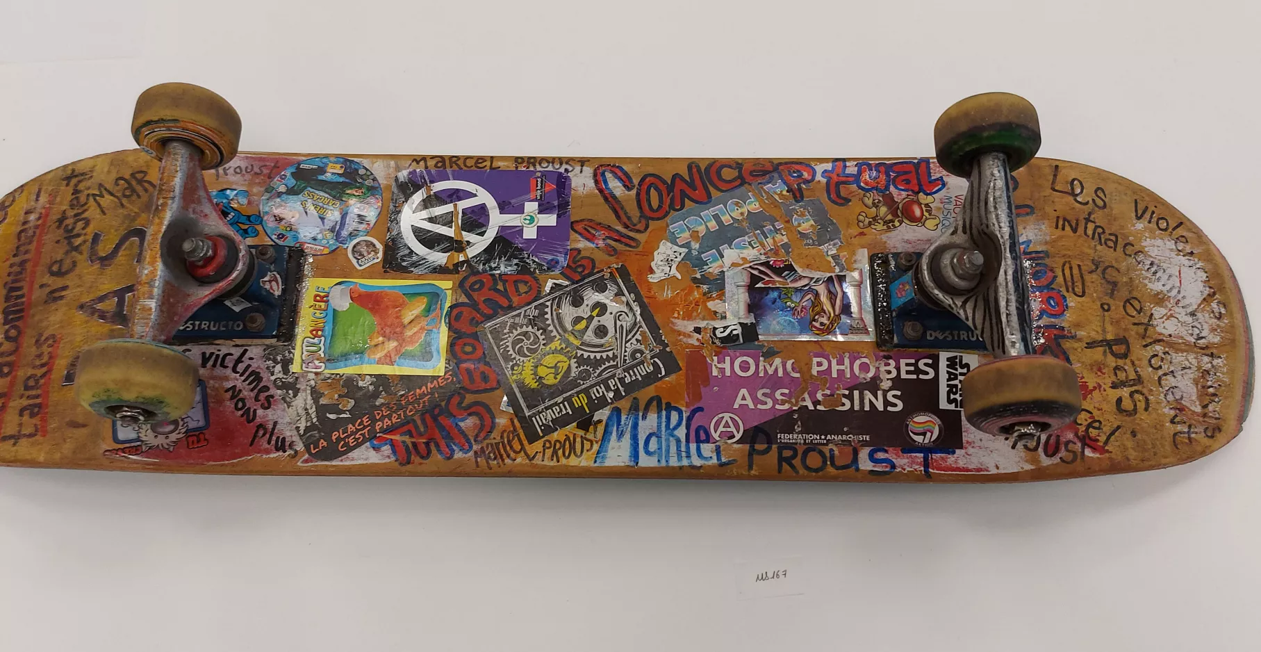 Skate board en bois customisé d'écritures et de dessins.
