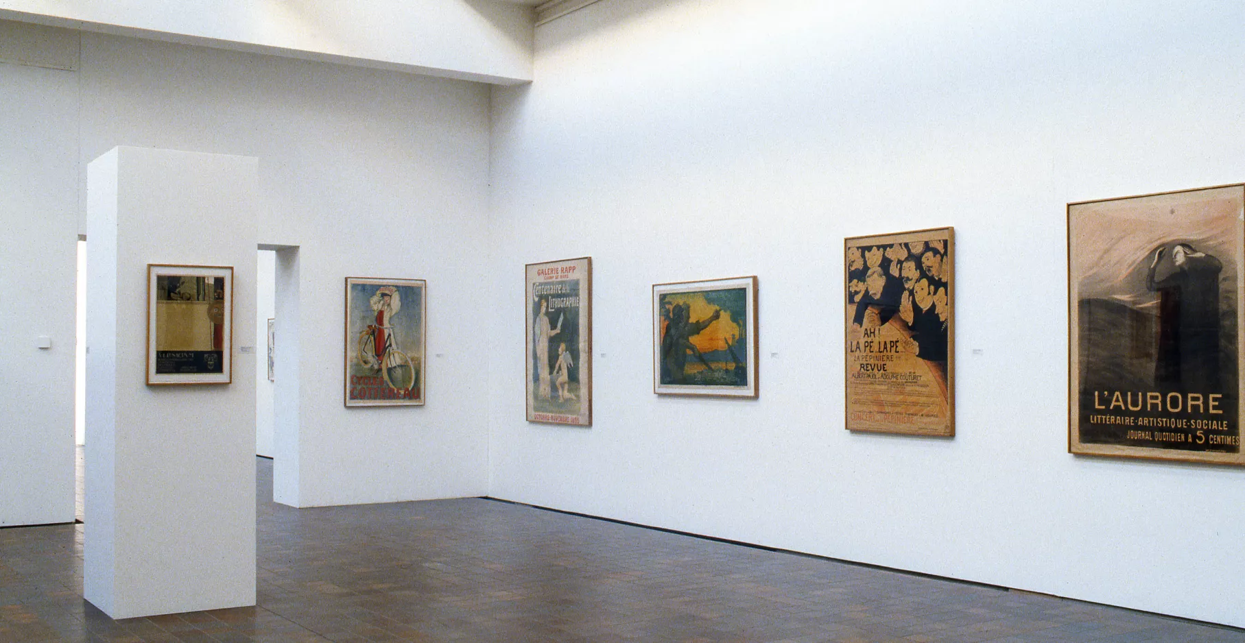 Salle d'exposition présentant des toiles.