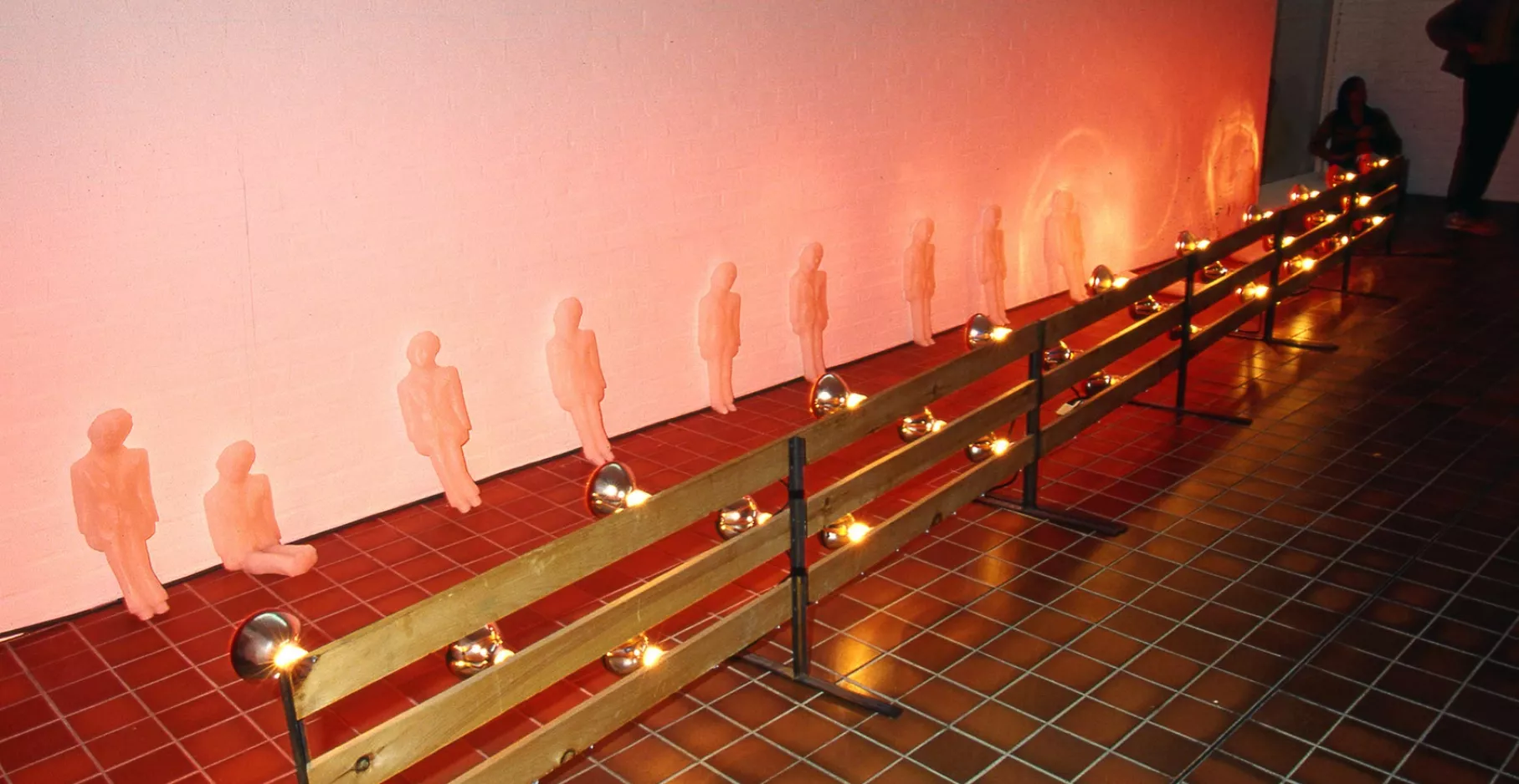 Sculpture miniature de cire devant des lampes chauffantes.