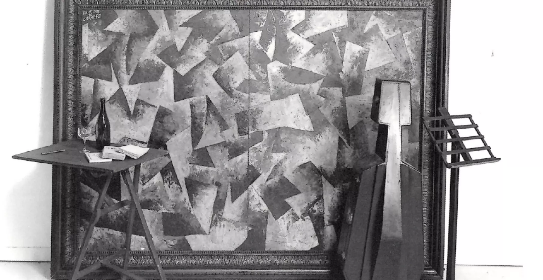 Œuvre en 3D, un tableau, un violon, un trépied et une table.